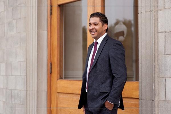 Man in a suit standing outside a campus building