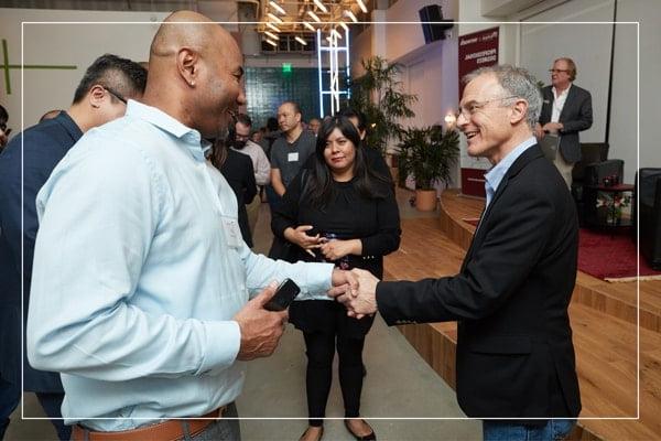 Two men in formal wear shaking hands