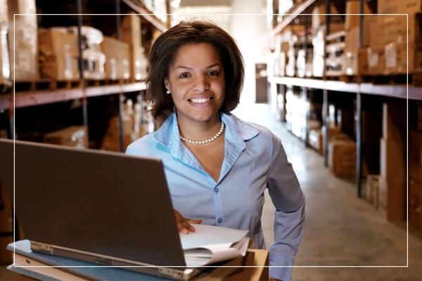 Woman sitting in front of her laptop and smiling at the camera